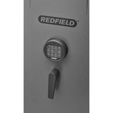 Close-up of a Redfield gun safe's door featuring the brand name in bold letters, a digital keypad for a programmable electronic lock, and a black drop handle, all set against the safe's grey surface.