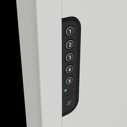 Close-up of the illuminated electronic keypad on the white in-wall safe, offering easy and secure access.